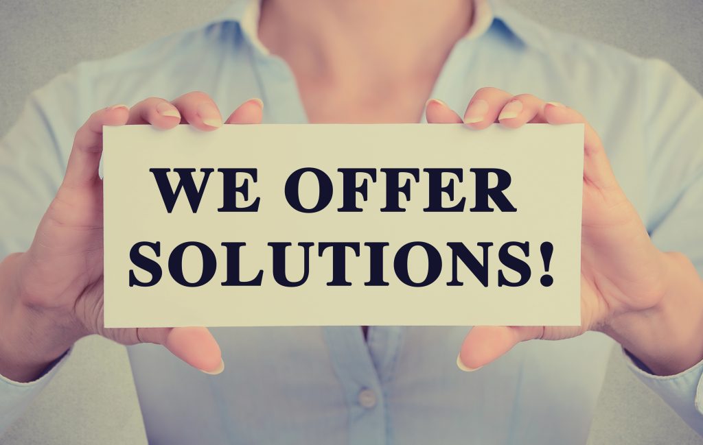 guy holding a note which says "we offer solutions"